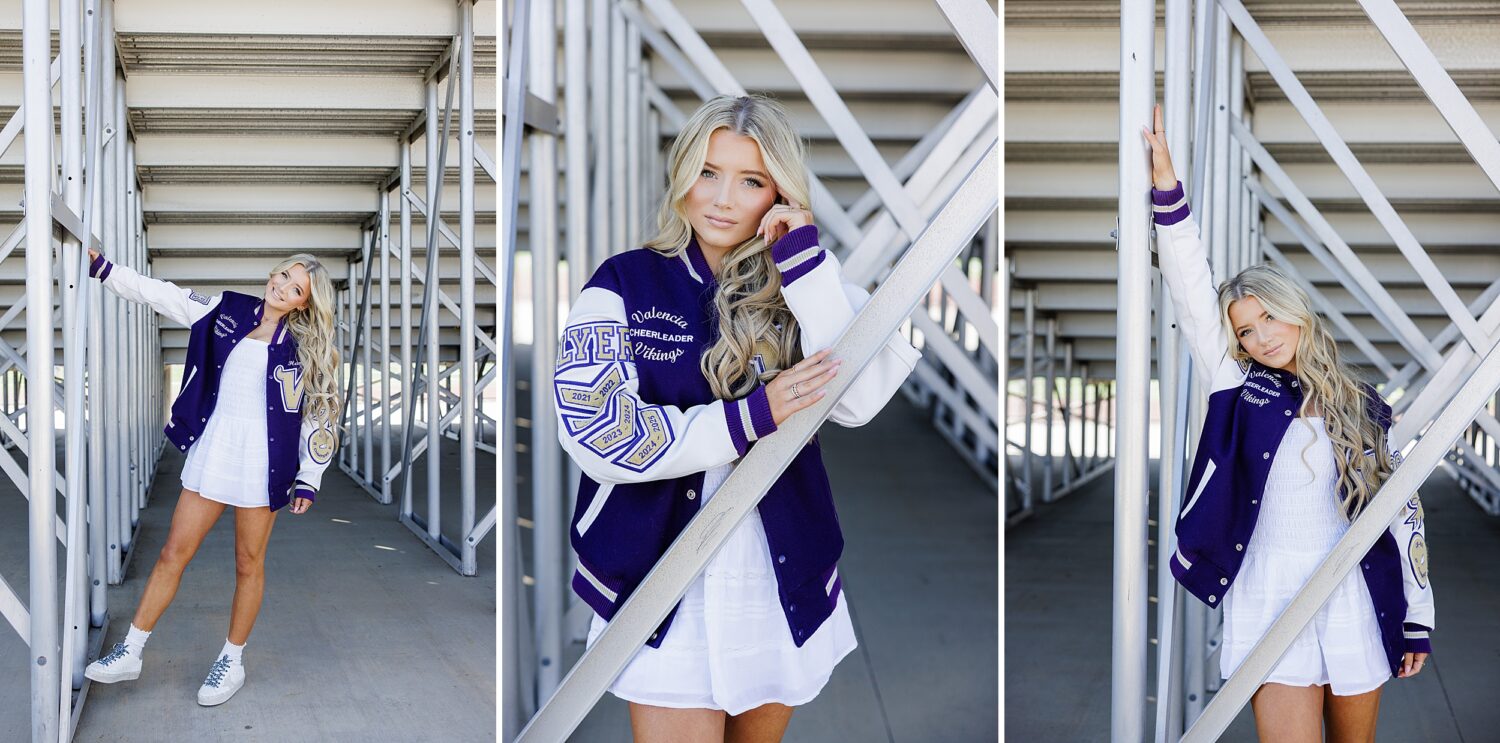 High school senior posing under bleachers with varsity cheer jacket during her Valencia California senior session.