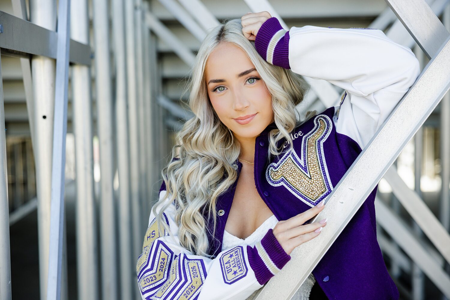 Close-up senior portrait of a Valencia High School cheerleader wearing her custom varsity letterman jacket in Santa Clarita.